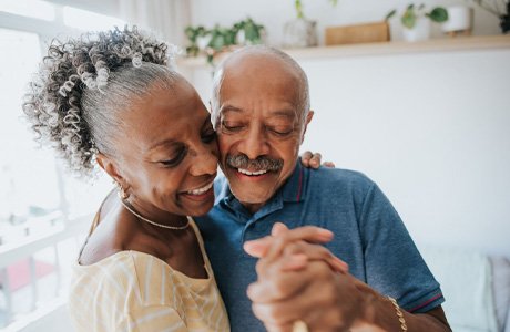 elderly couple holding hands and dancing together