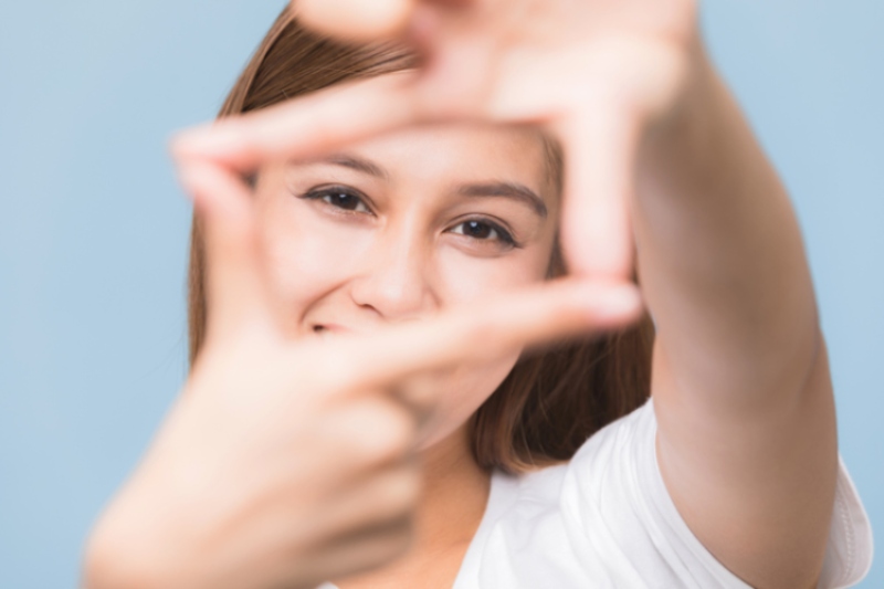 woman holding up a frame with her hands