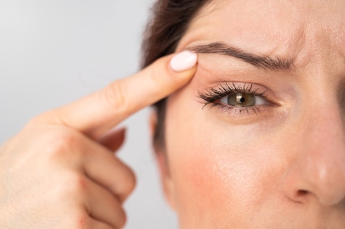 Woman raising her eyebrow up with her pointer finger