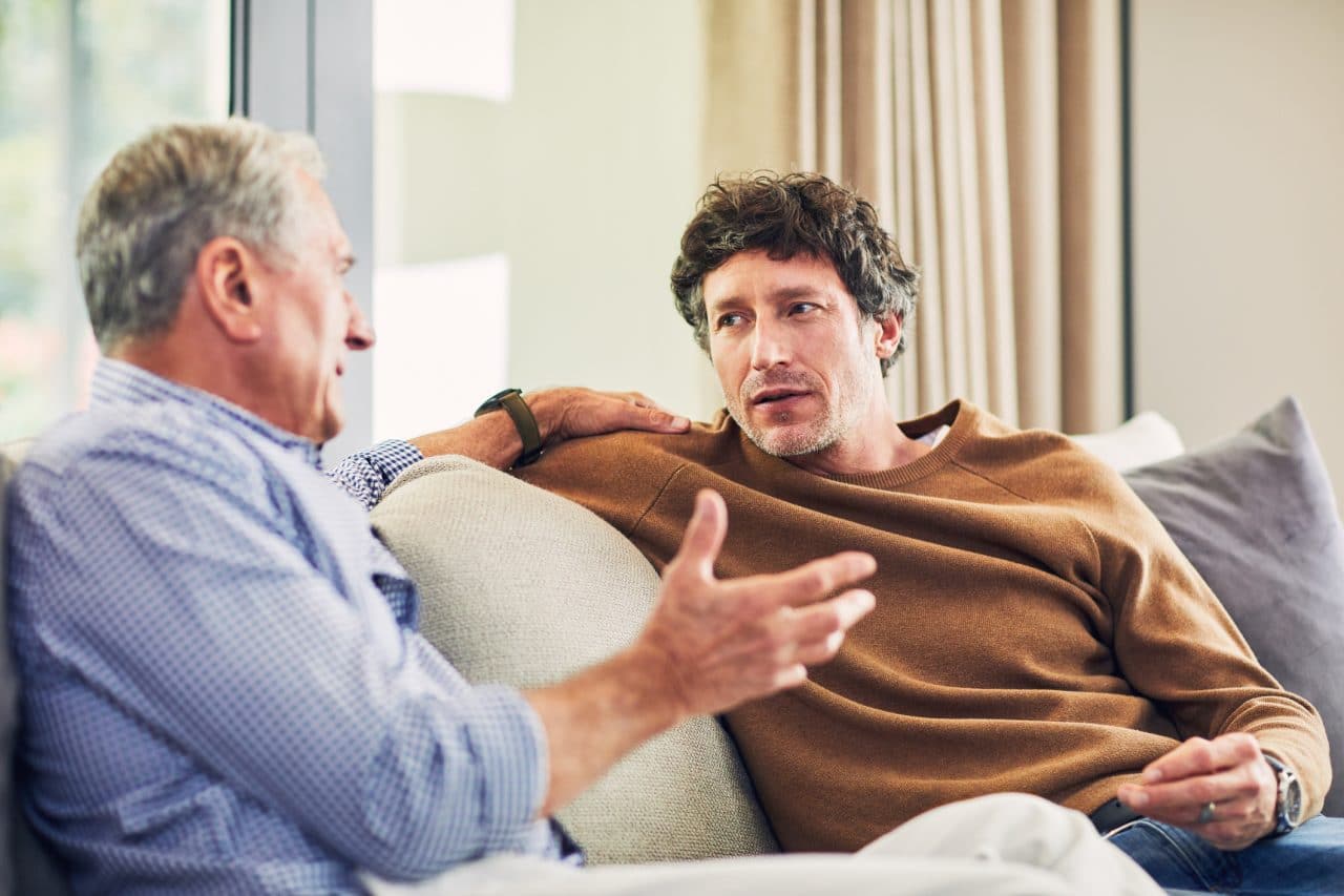 father and son sitting on the couch talking