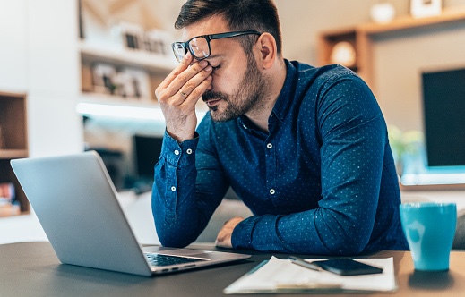 A man sitting at his desk looking agitated