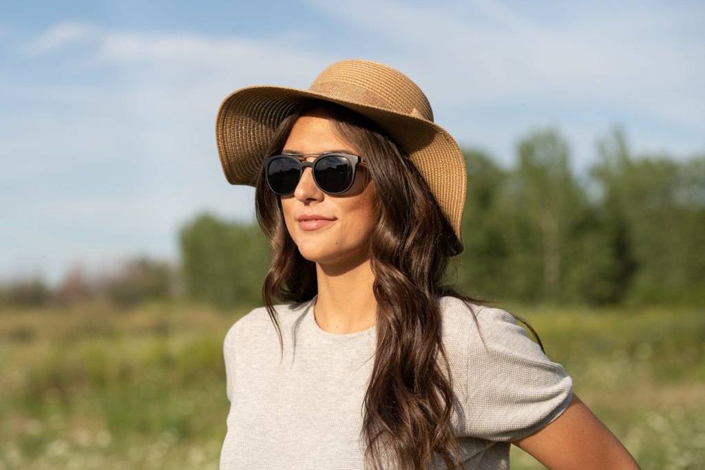 young lady with brown hair wearing a hat and sunglasses