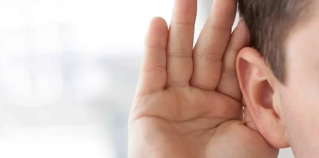 Kid holding his hand to his ear listening