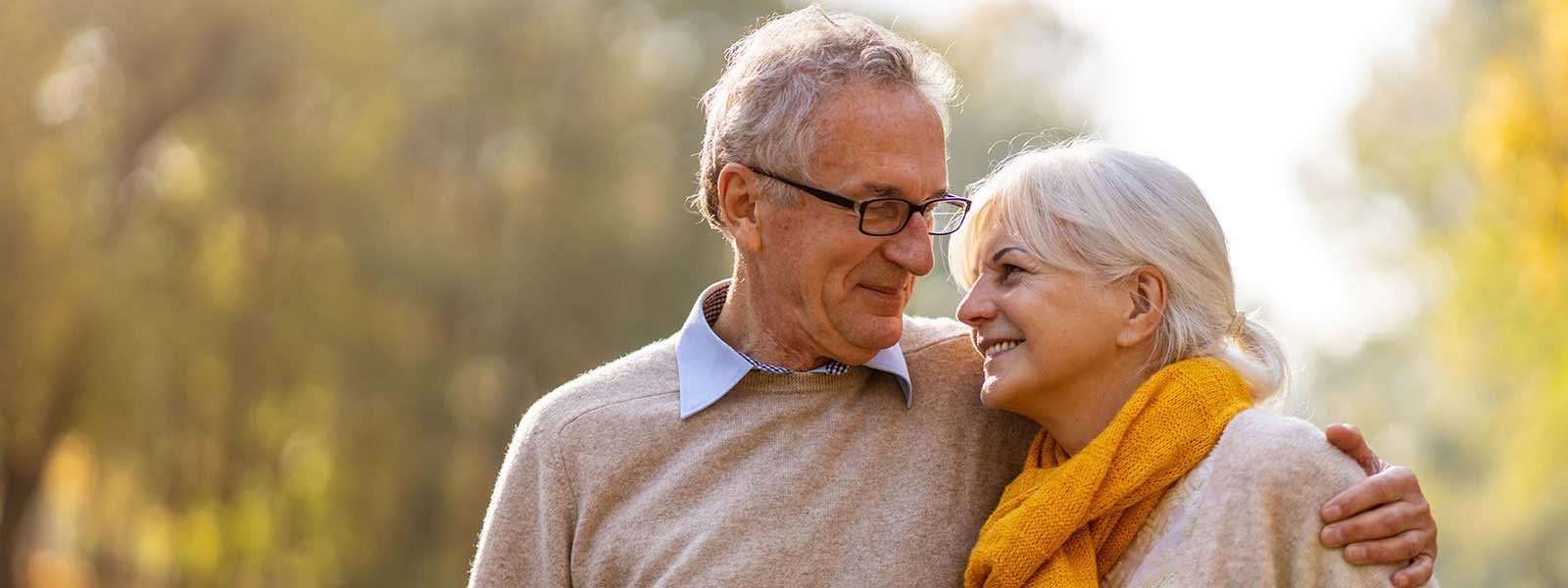 An older couple standing outside together